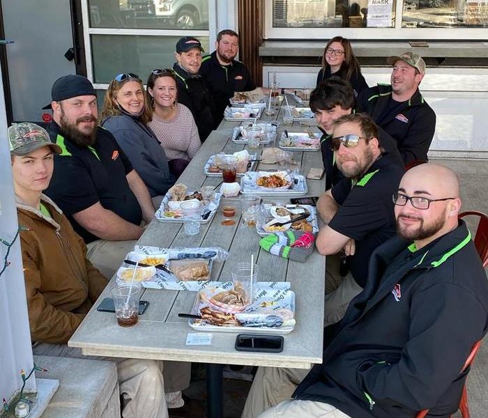 SERVPRO employees gathered for a lunch meeting at a picnic table