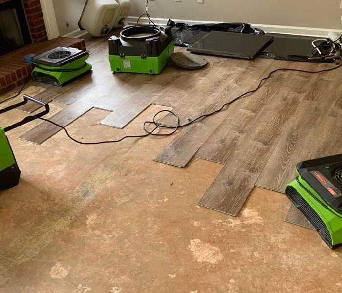 SERVPRO green drying equipment placed on removed and salvaged flooring